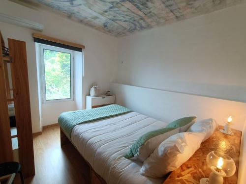 a bedroom with two beds and a window at Casa Sol Nascente in Ponta Delgada