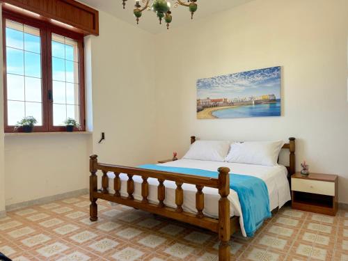 a bedroom with a bed and a painting on the wall at Casa Tonia - Baia Verde in Baia Verde