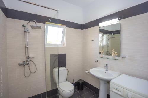 une salle de bains avec douche, toilettes et lavabo dans l'établissement Notos Villas, à Frangokastello