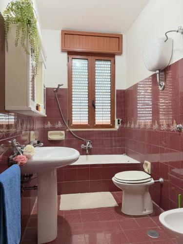 a bathroom with a sink and a toilet and a tub at Casa Tonia - Baia Verde in Baia Verde