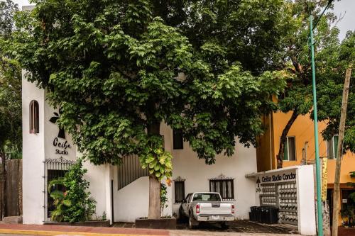a truck parked in front of a white building at Ceiba Studios in Zihuatanejo