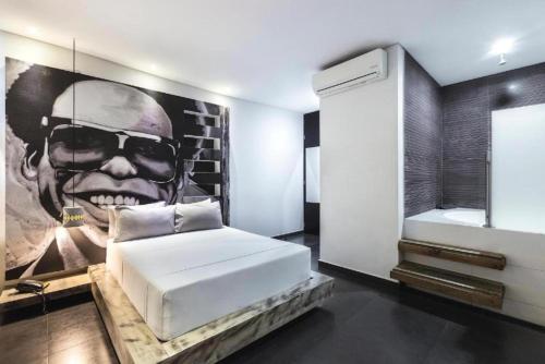 a bedroom with a bed and a painting of a man at Hotel Medellin Arte in Medellín