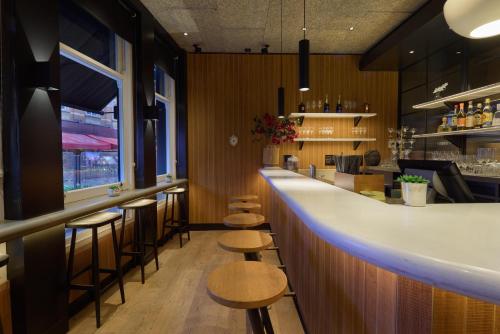 a bar in a restaurant with stools at Radisson Blu Hotel, London Leicester Square in London
