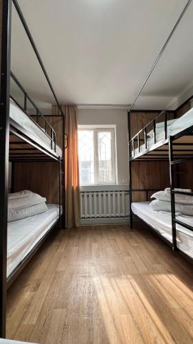 two bunk beds in a room with a wooden floor at Sayakatchy hostel in Bishkek