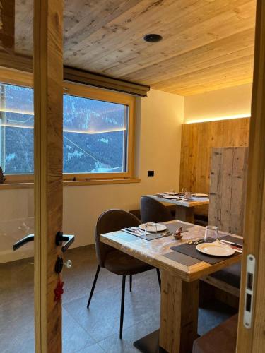 ein Esszimmer mit Tisch und Stühlen und einem Fenster in der Unterkunft Gran Zebrú B&B - high mountain in Valfurva