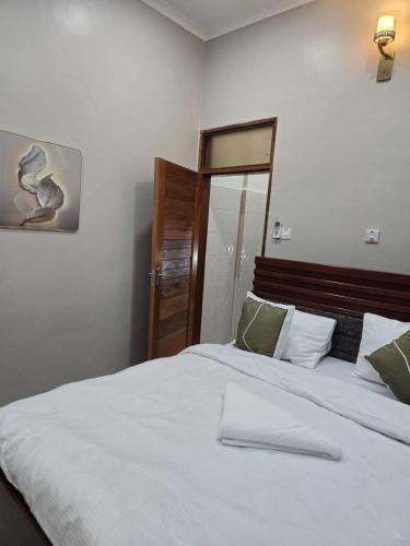 een slaapkamer met een groot wit bed met groene kussens bij Kibs apartments in Dodoma