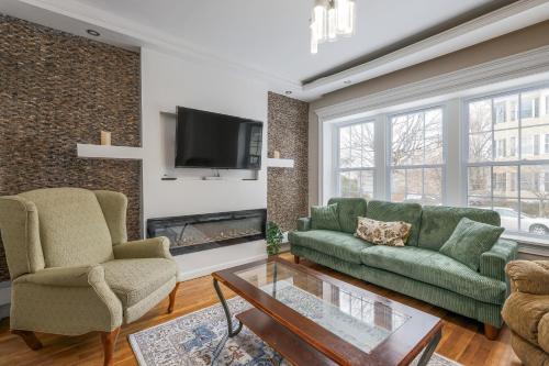 a living room with two green couches and a fireplace at Fairmont Suites in Worcester