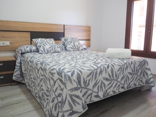a bedroom with a bed with a laptop on it at El Origen in Carboneras de Guadazaón