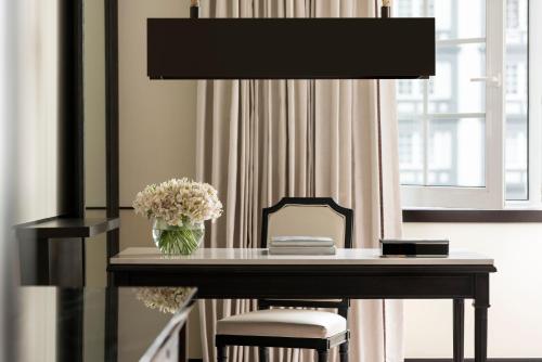 a desk with a vase of flowers and a lamp at Four Seasons Hotel Mexico City in Mexico City