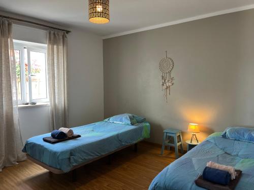 een slaapkamer met twee bedden en een raam bij Quinta Samor in Aljezur