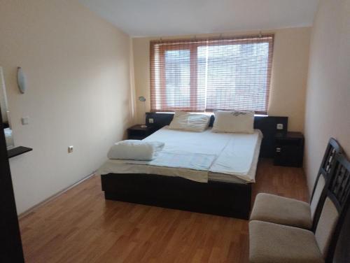 a bedroom with a bed and a chair and a window at Sea view in Sozopol
