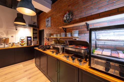Una cocina de restaurante con un mostrador y una pared de ladrillos. en Le Petit, en Bratislava