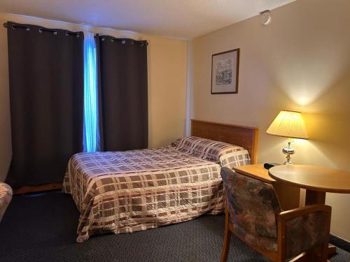 a hotel room with a bed and a table at Discovery Inn in Yellowknife