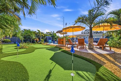 a golf course with orange umbrellas and chairs on it at Resort Style Backyard Pool Hot Tub Games in Seminole