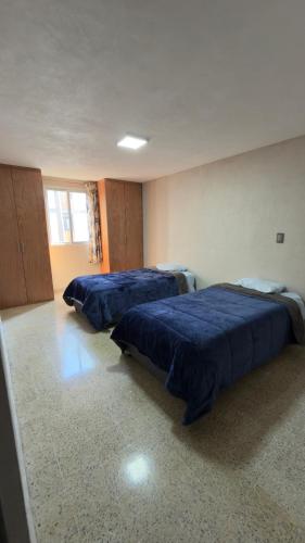 Dos camas en una habitación con sábanas azules. en Departamento cerca de Polanco Nueva Embajada USA y el Hospital Militar, en Ciudad de México