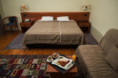 a hotel room with a bed and a tray of food at Hotel Terex in Sarajevo