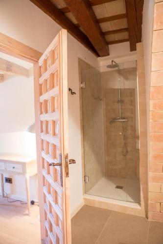 a shower with a glass door in a bathroom at Casa rural Masia Les Apieres. in El Pla de Manlleu