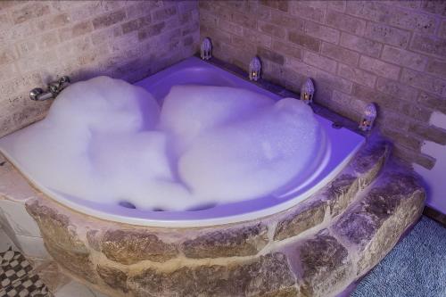 Una bañera llena de nieve en una habitación. en צימר old school, en Ein Kinya