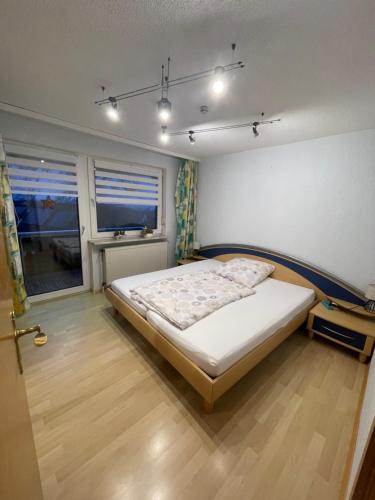 Un dormitorio con una cama en una habitación con ventana. en Ferienwohnung Matthias Lang, en Rugendorf