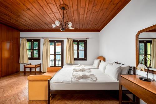 a bedroom with a large bed with a wooden ceiling at Mandraki Paradise in Meyisti