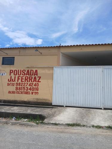 a building with a sign on the side of it at Pousada JJFerraz in Guaratinguetá