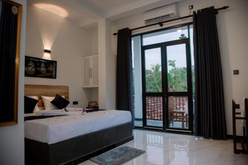 een slaapkamer met een groot bed en een groot raam bij Seaside Serenity Resort in Hiriketiya