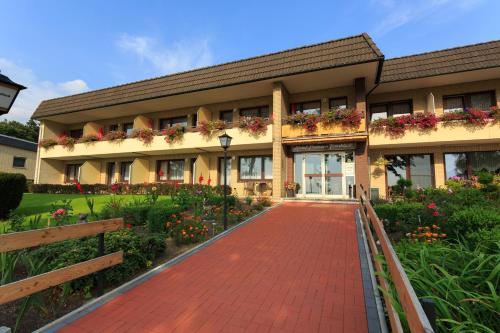 a building with a red brick walkway in front of it at Hotel Pension Fernblick in Sankt Andreasberg