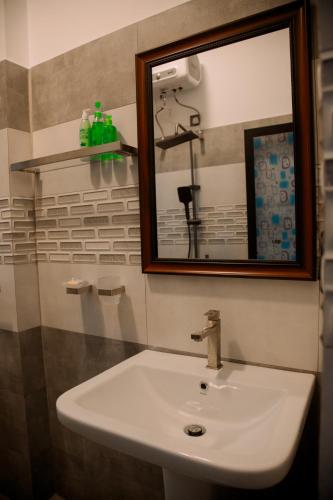 a bathroom with a white sink and a mirror at Seaside Serenity Resort in Hiriketiya