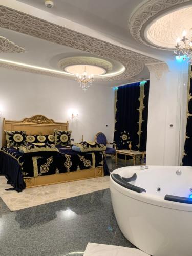 a bedroom with a bed and a tub in a room at HOTEL Diar Jenna in Annaba