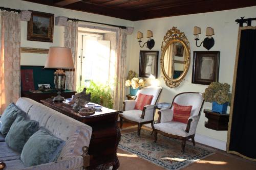 sala de estar con sofá, sillas y espejo en Casa do Barreiro de Cima, en Mondim de Basto
