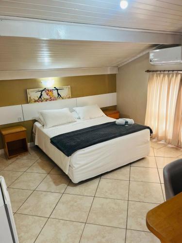 a bedroom with a large white bed in a room at Pousada Ruppenthal in Canela