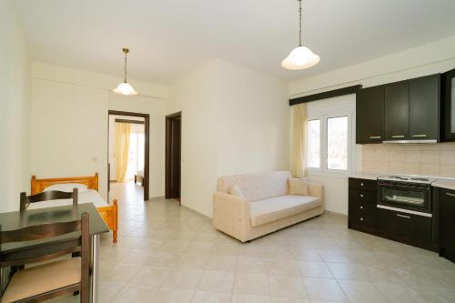 Una cocina y una sala de estar con un sofá y una mesa. en Acherontas Rooms 1, en Vouvopótamos