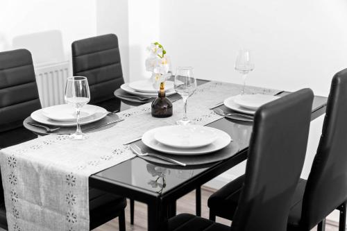 a dining room table with plates and wine glasses at Charming 2-Bedroom Home - Garden & Driveway Parking 20SL in Birmingham