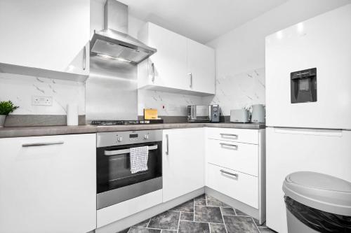 a kitchen with white cabinets and a stove top oven at Charming 2-Bedroom Home - Garden & Driveway Parking 20SL in Birmingham