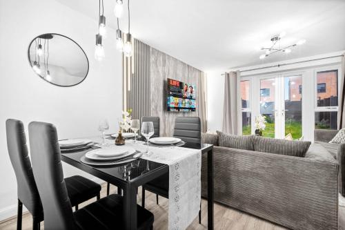 a dining room with a table and a couch at Charming 2-Bedroom Home - Garden & Driveway Parking 20SL in Birmingham