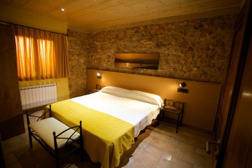 a bedroom with a large bed and two chairs at Casa Llebra I in Tortosa