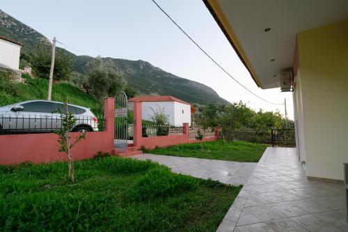 una casa con un coche aparcado junto a una valla en Acherontas Rooms 1, en Vouvopótamos