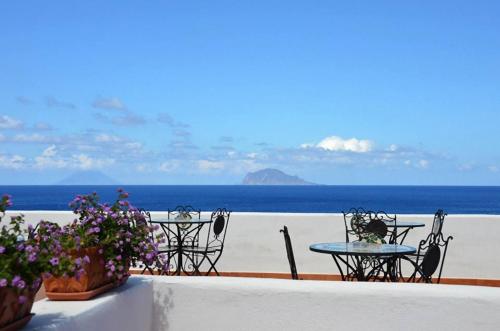 a table and chairs with a view of the ocean at Hotel Punta Barone in Santa Marina Salina