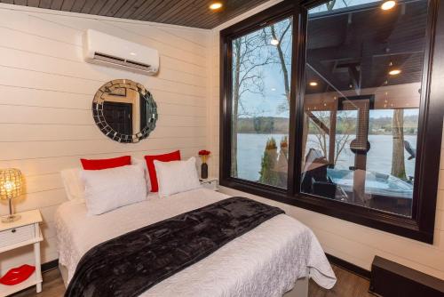 a bedroom with a bed and a large window at Black Tie Affair - Eloquent Riverfront Experience in New Richmond