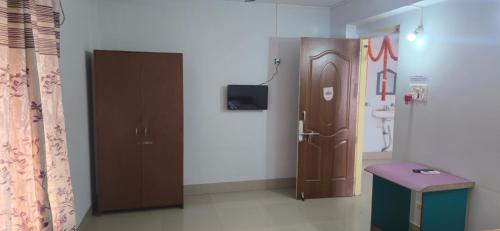 ein Badezimmer mit Toilette, Tür und Hocker in der Unterkunft Atithi Guest House in Pūrnia