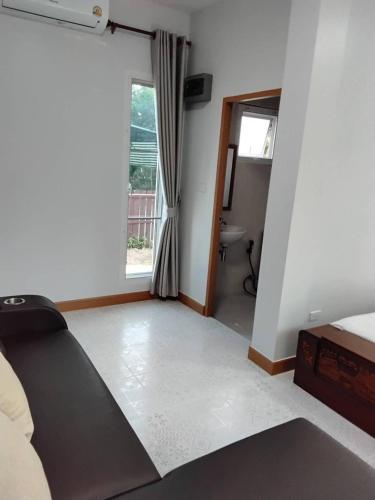 a living room with a bed and a window at Huan Janto Homestay - Nimmanaradee in Ban Sam Lang