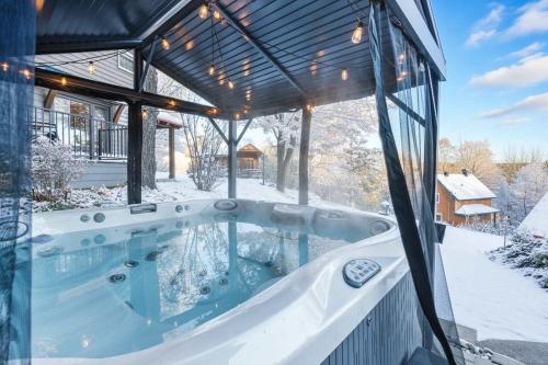 Spa & Nature view - Alpenglow في Sainte-Germaine-du-Lac-Etchemin: حوض استحمام ساخن في الثلج في المنزل