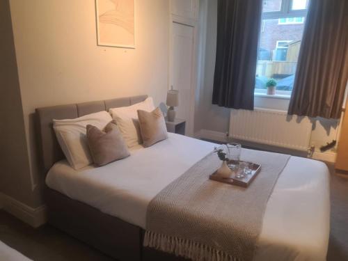 ein Schlafzimmer mit einem großen Bett und einem Tablett darauf in der Unterkunft City North Apartment in Longbenton