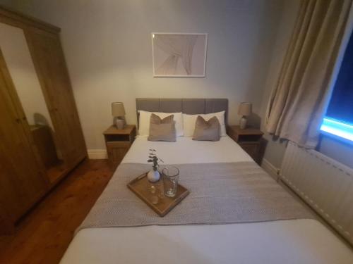 ein Schlafzimmer mit einem weißen Bett und einem Tablett darauf in der Unterkunft City North Apartment in Longbenton