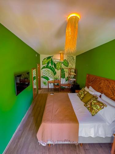 a bedroom with green walls and a large bed at Villa Jaguar Fortim in Fortim