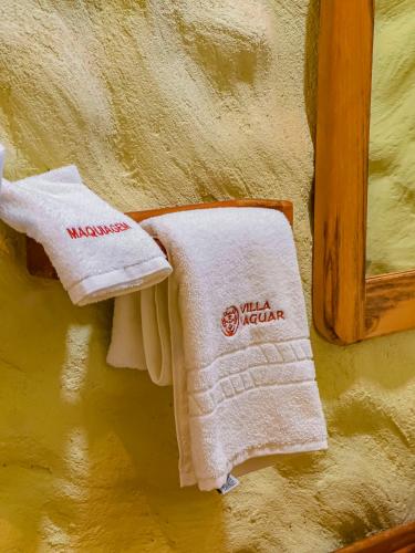 two towels hanging on a wall next to a mirror at Villa Jaguar Fortim in Fortim