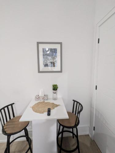 a white table with two chairs and a remote control on it at Brand New Private Unit with Parking, Steps to TTC, 15 Minutes to Downtown in Toronto