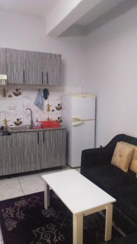 una cucina con un divano e un frigorifero bianco di IGIKARI residence a Kigali