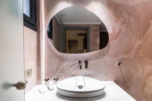 ein Badezimmer mit Waschbecken und Spiegel in der Unterkunft Aria Stay in Drama