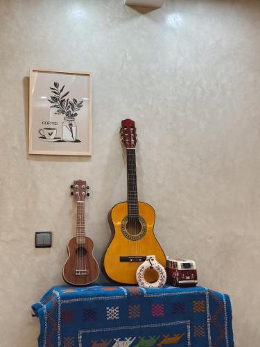 two acoustic guitars are hanging on a wall at Cool Surfers in Tamraght Ouzdar